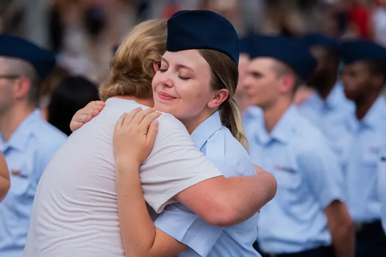 Air Force graduate embracing a family member at basic training graduation